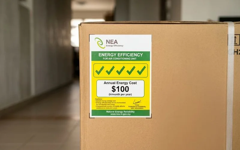 NEA energy label on aircon unit showing tick rating and annual energy cost information
